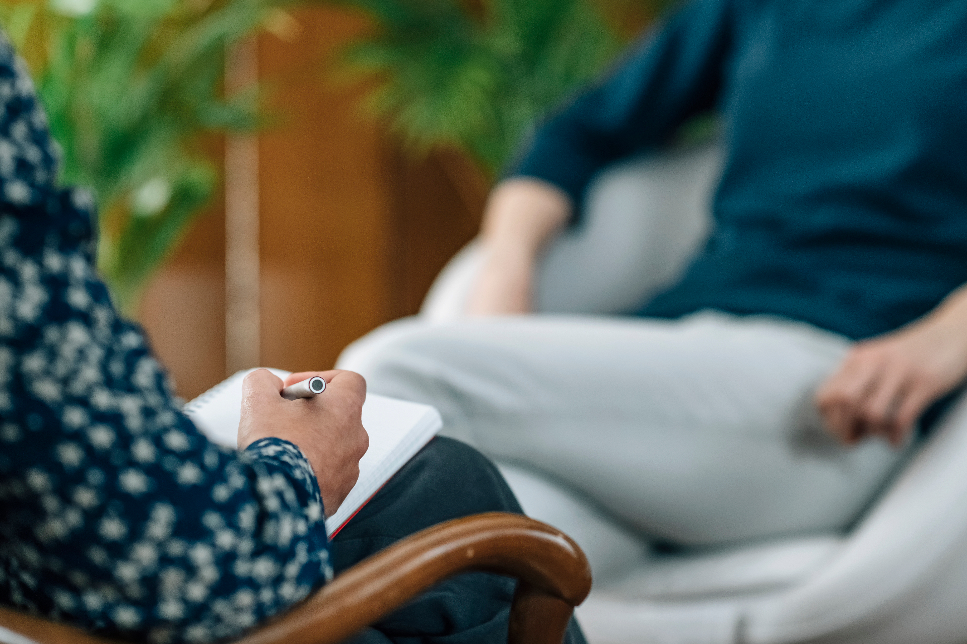 Person in einer therapeutischen Sitzung macht sich Notizen